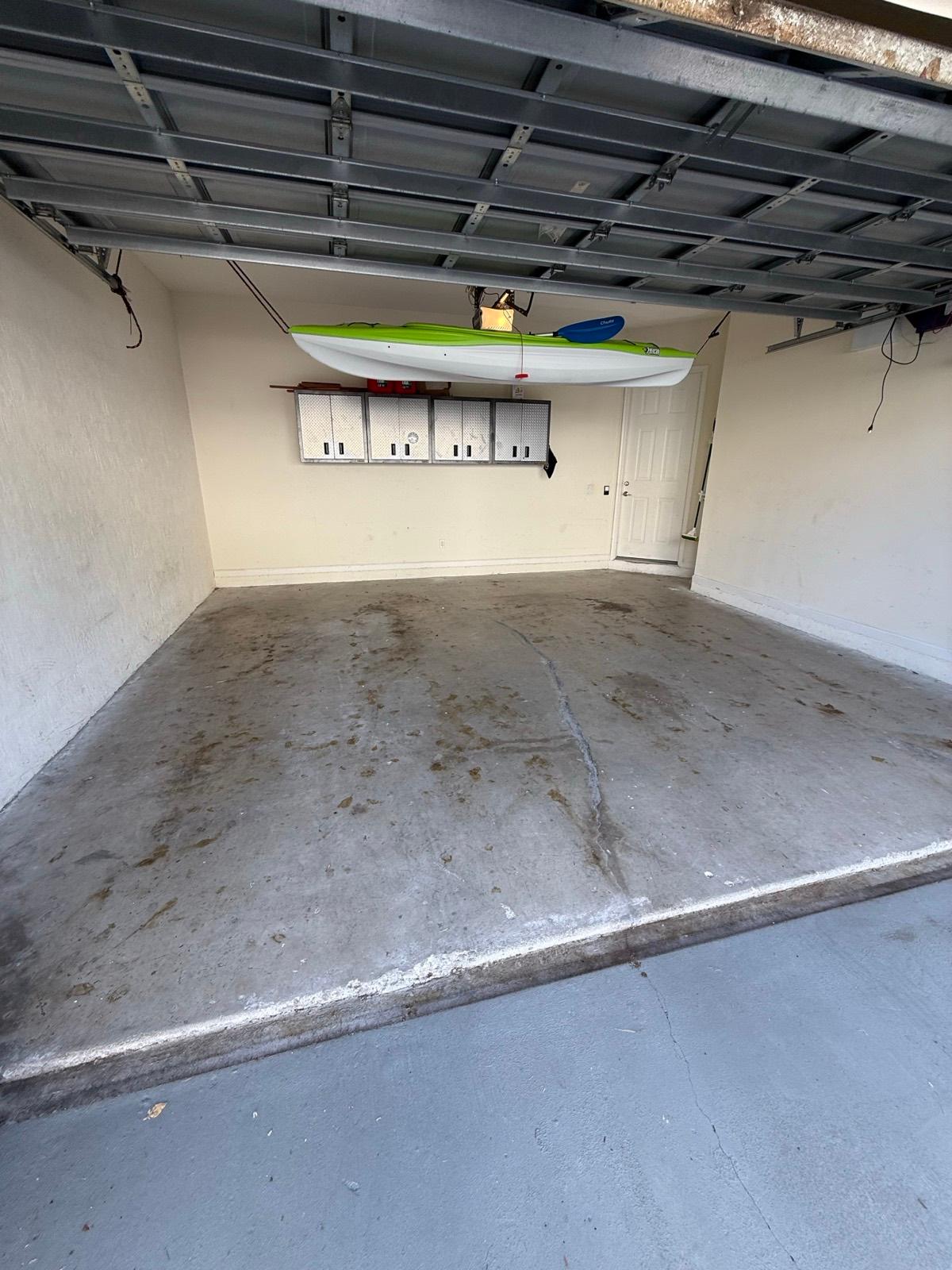 Bare stained concrete garage floor before epoxy coating in Boca Raton, FL