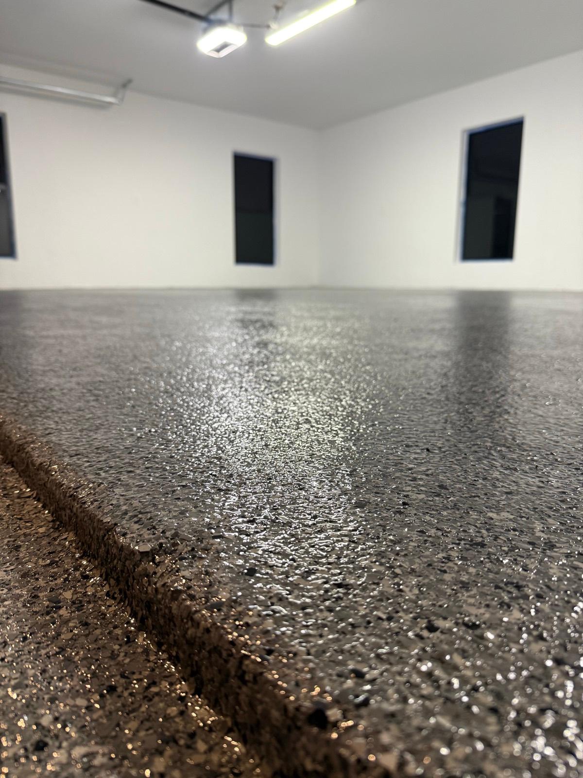 Close-up of gray flake epoxy garage floor texture installed by Resin Masters in Pompano Beach, FL