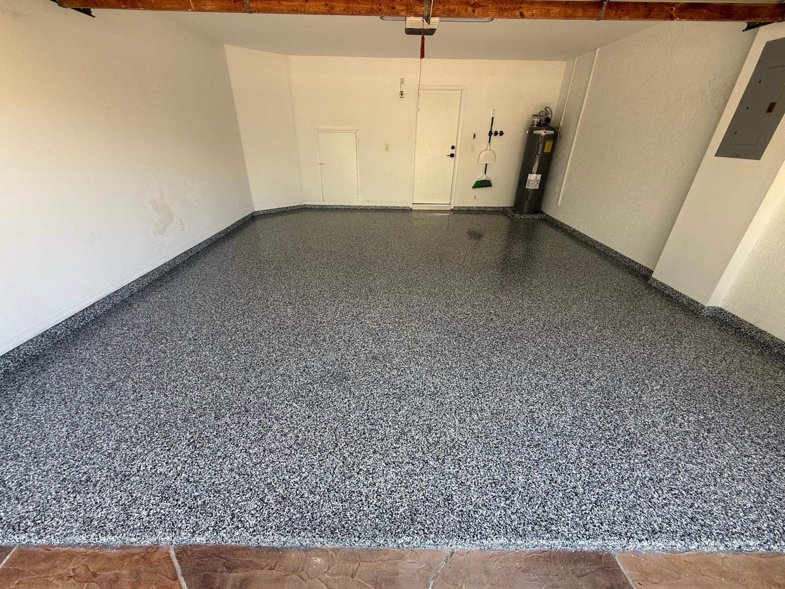 Two-car garage with gray full flake epoxy floor installed by Resin Masters in Royal Palm Beach, FL