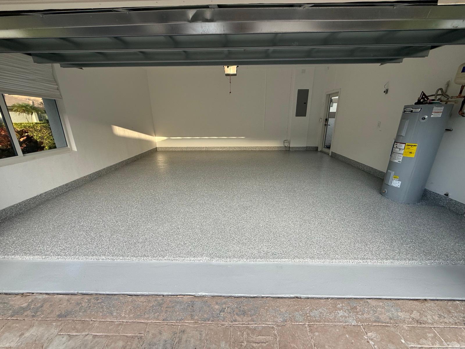 Bright light-colored epoxy floor in a spacious garage installed by Resin Masters in Highland Beach, FL