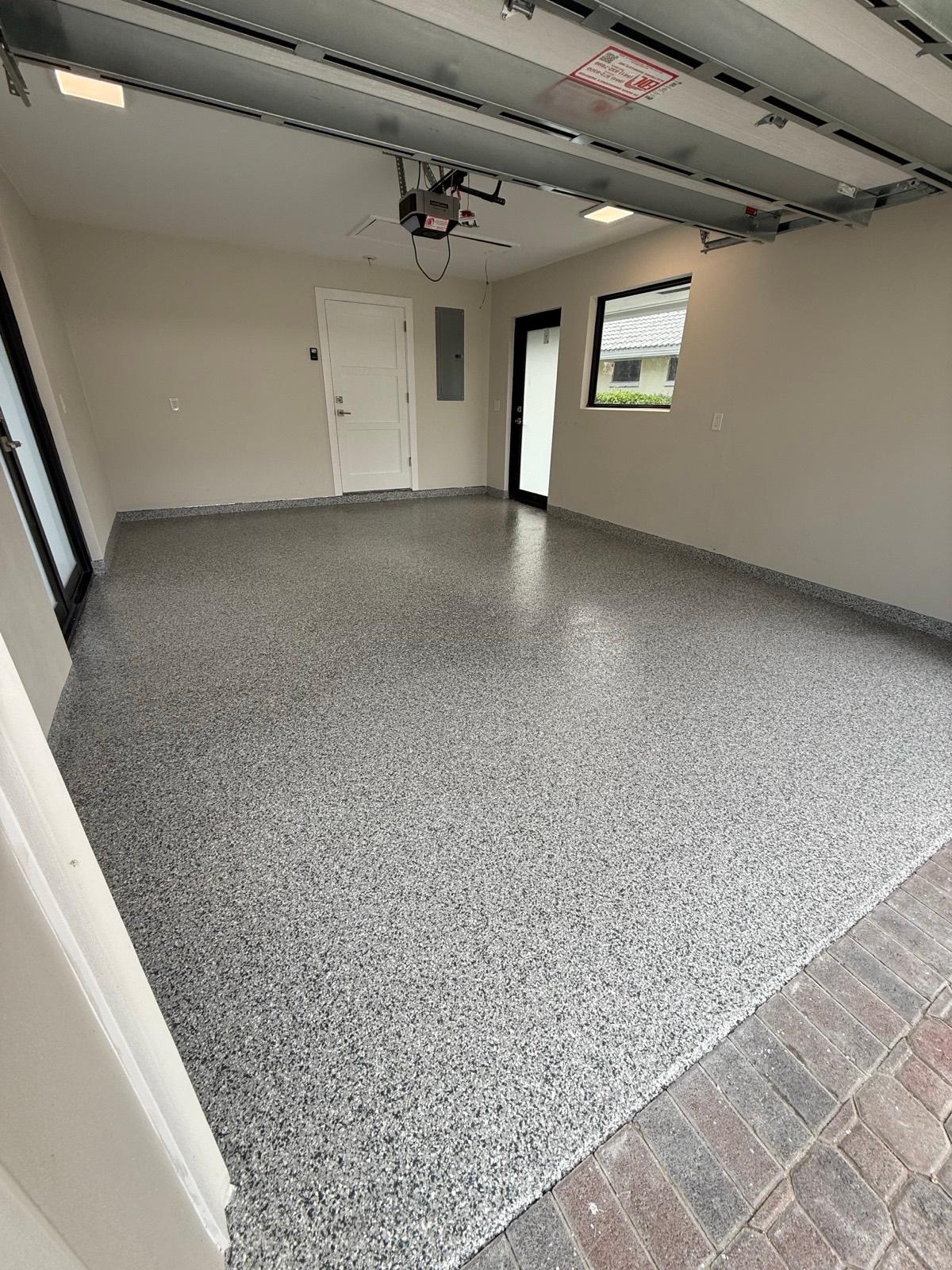 Tan flake epoxy garage floor with decorative blend installed by Resin Masters in Boca Raton, FL